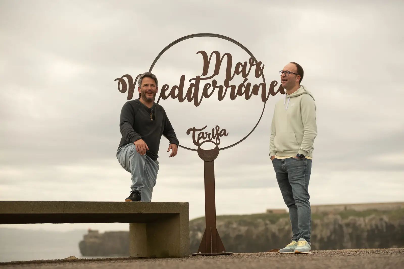 Pablo y Fran, fundadores de Aire, junto al cartel del mar Mediterráneo en el paseo de Tarifa.